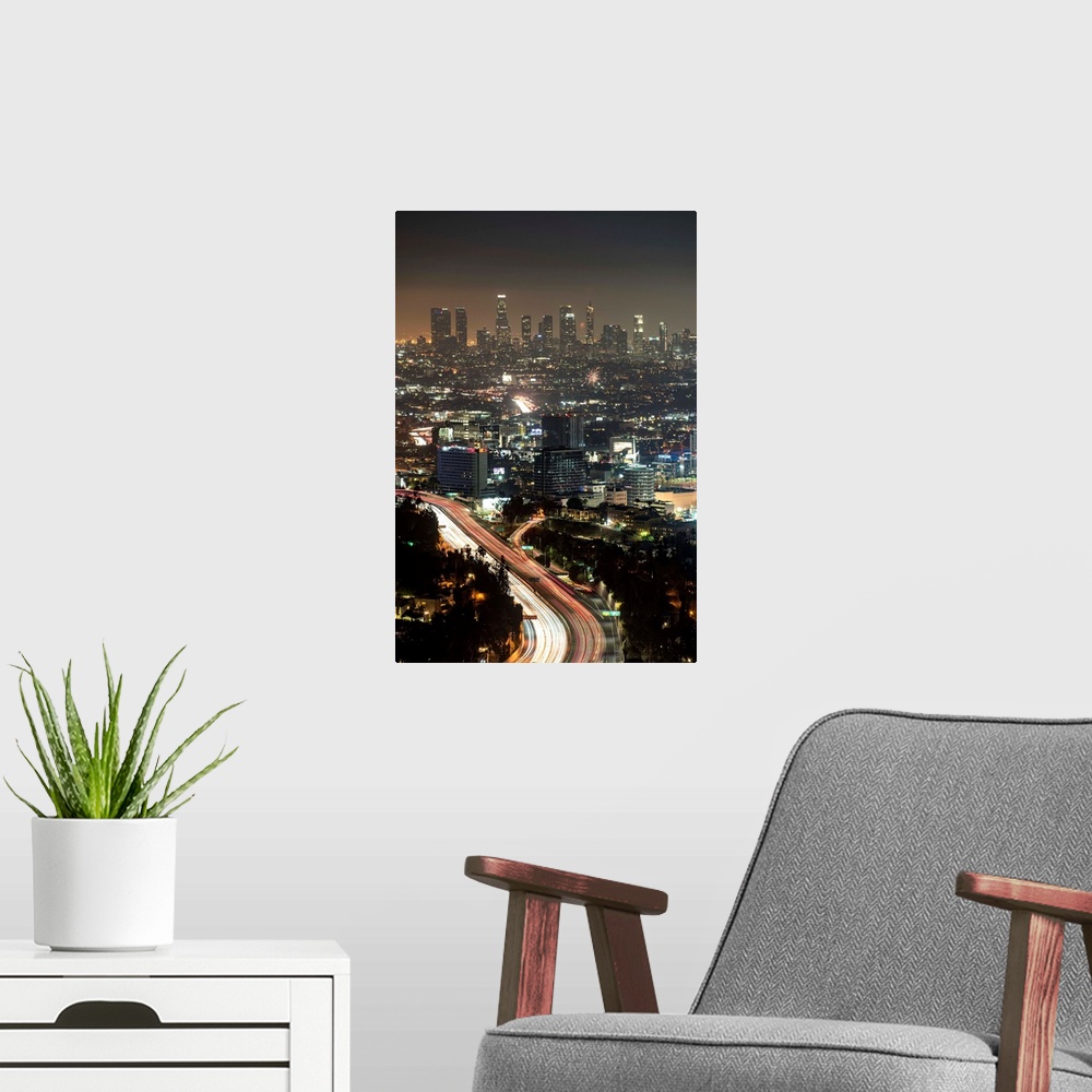 A modern room featuring Aerial view photograph of Los Angeles, California with a hazy skyline at night.
