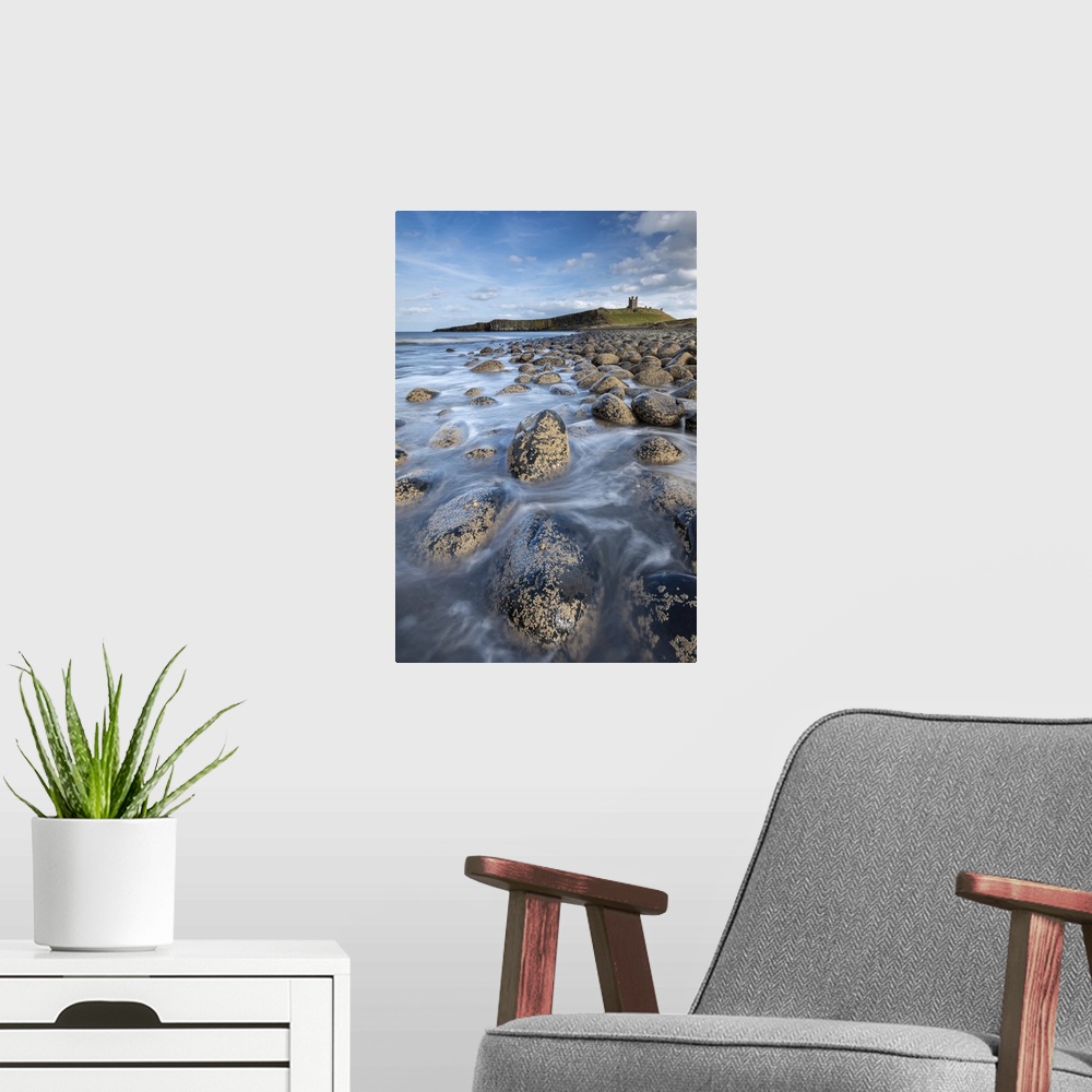 A modern room featuring Dunstanburgh Castle from the rocky shores of Embleton Bay, Northumberland, England, United Kingdo...