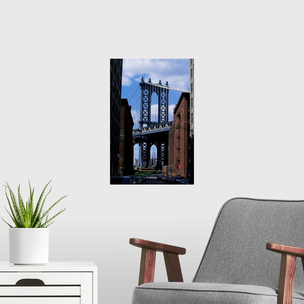 A modern room featuring Empire State Building in distance seen through Manhattan Bridge, Brooklyn, New York
