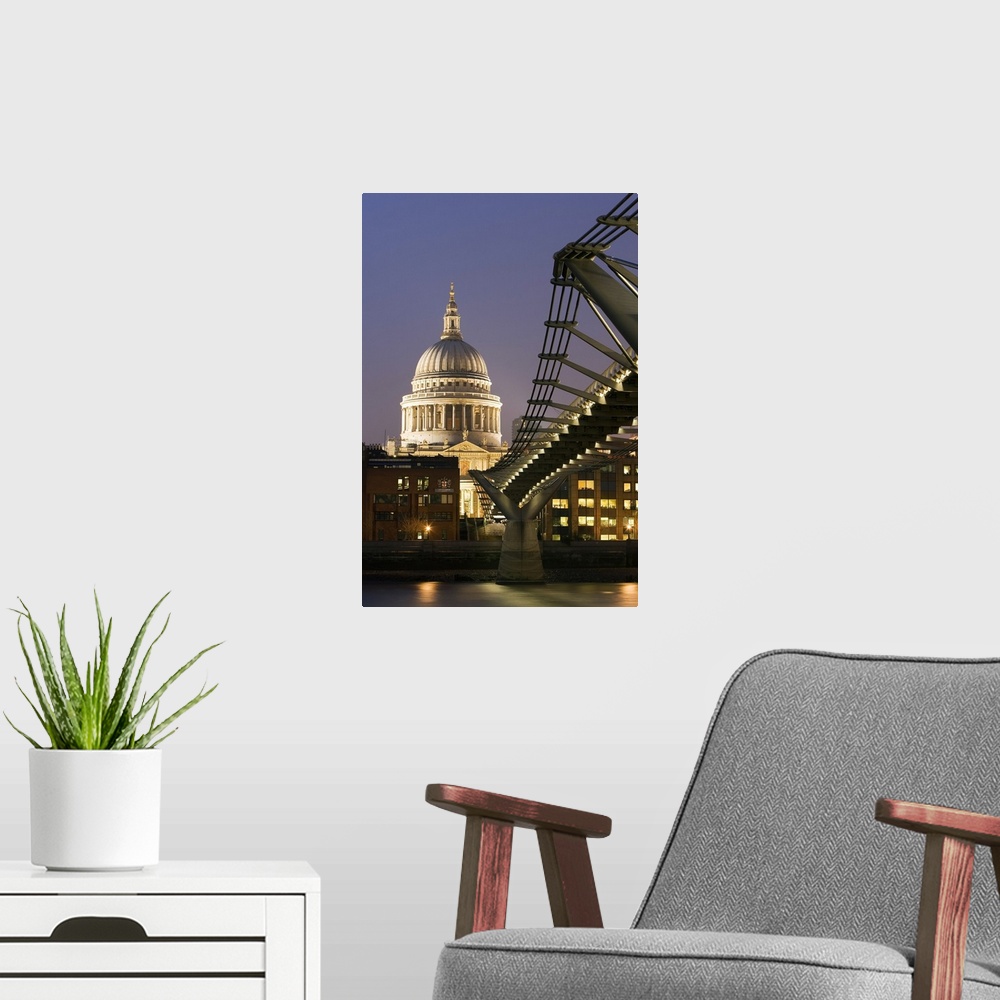 A modern room featuring Millennium Bridge and St. Pauls Cathedral, illuminated at dusk, London, England