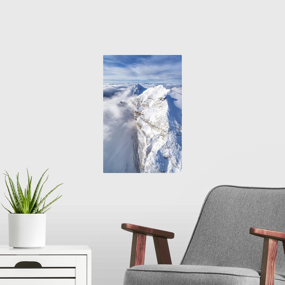 A modern room featuring Aerial view of snow capped Tofane group and scenic Freccia nel Cielo cableway, Dolomites, Belluno...