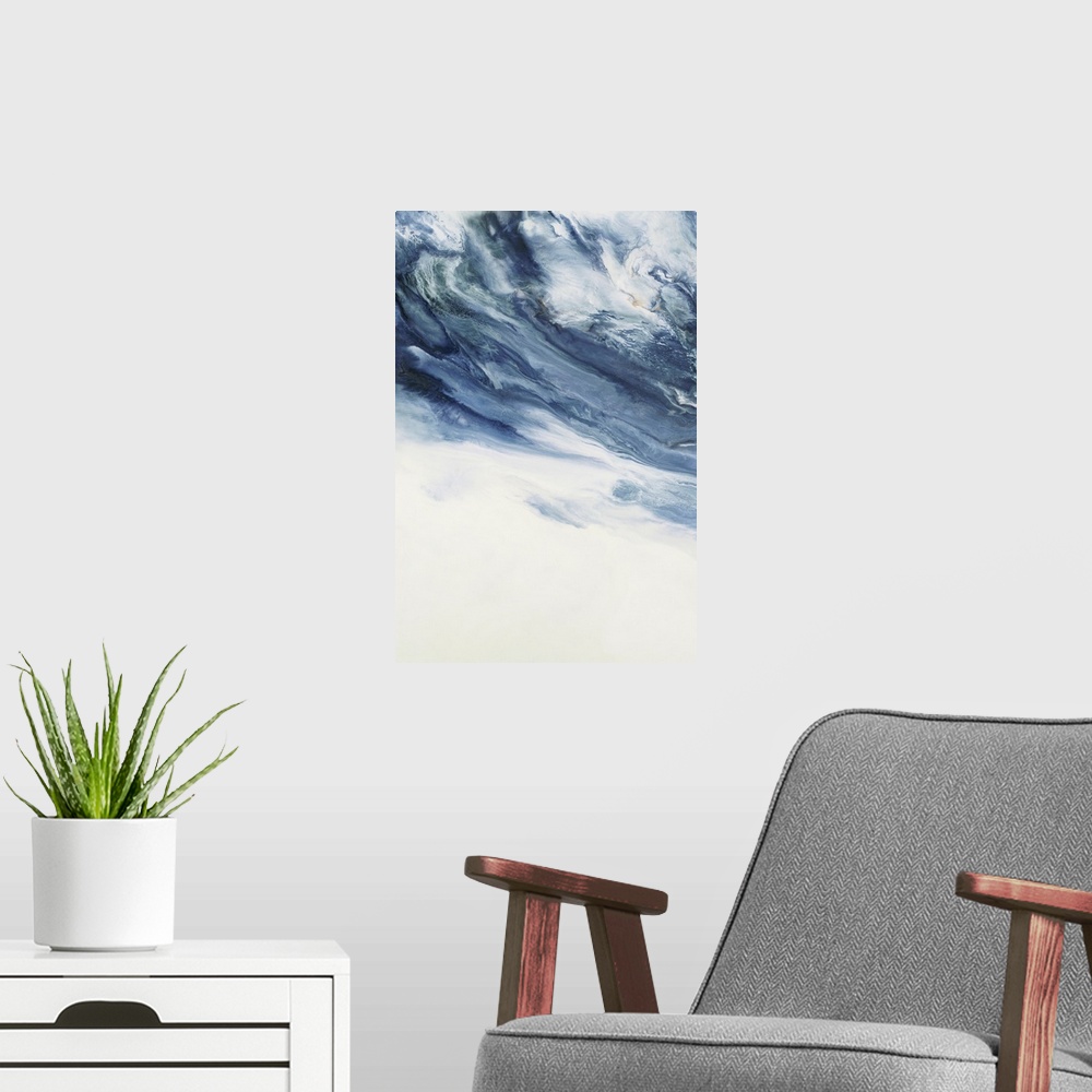 A modern room featuring Large abstract art with deep shades of blue marbling with white at the top and a solid white bottom.