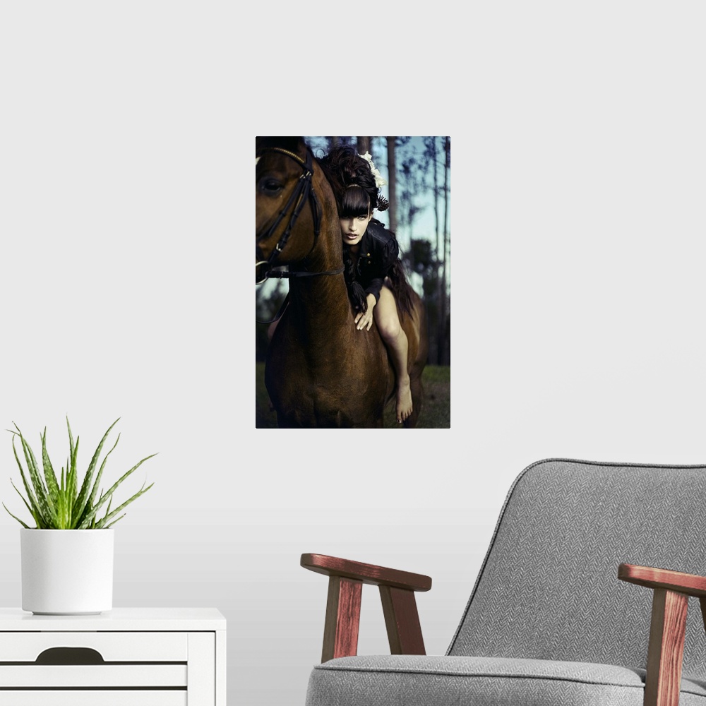 A modern room featuring Young woman with black hair sitting bare back on horse leaning forward towards the camera