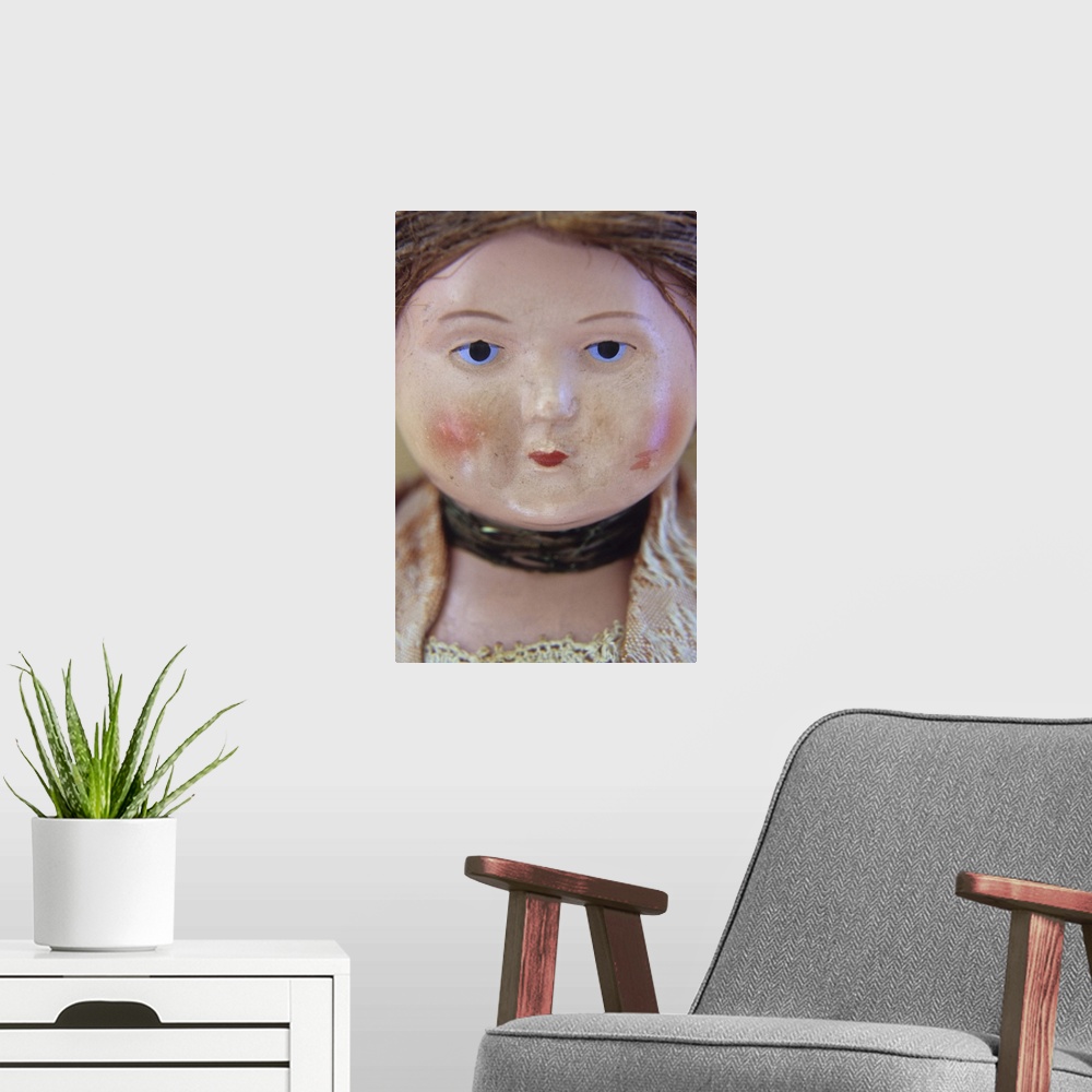 A modern room featuring Face of vintage woman doll with tight bun and glum face and wearing lacy clothes and neckband