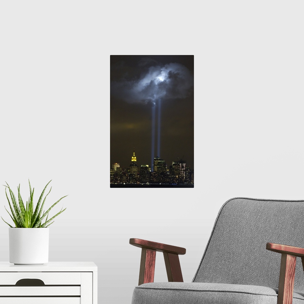 A modern room featuring Tribute in Light Memorial illuminates a passing cloud above lower Manhattan. Sept. 9, 2004. The t...