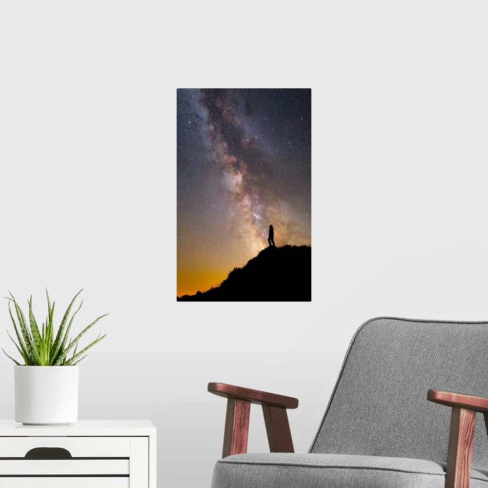 A modern room featuring A man on a mountain under the Milky Way on the Lago-Naki plateau in Russia.