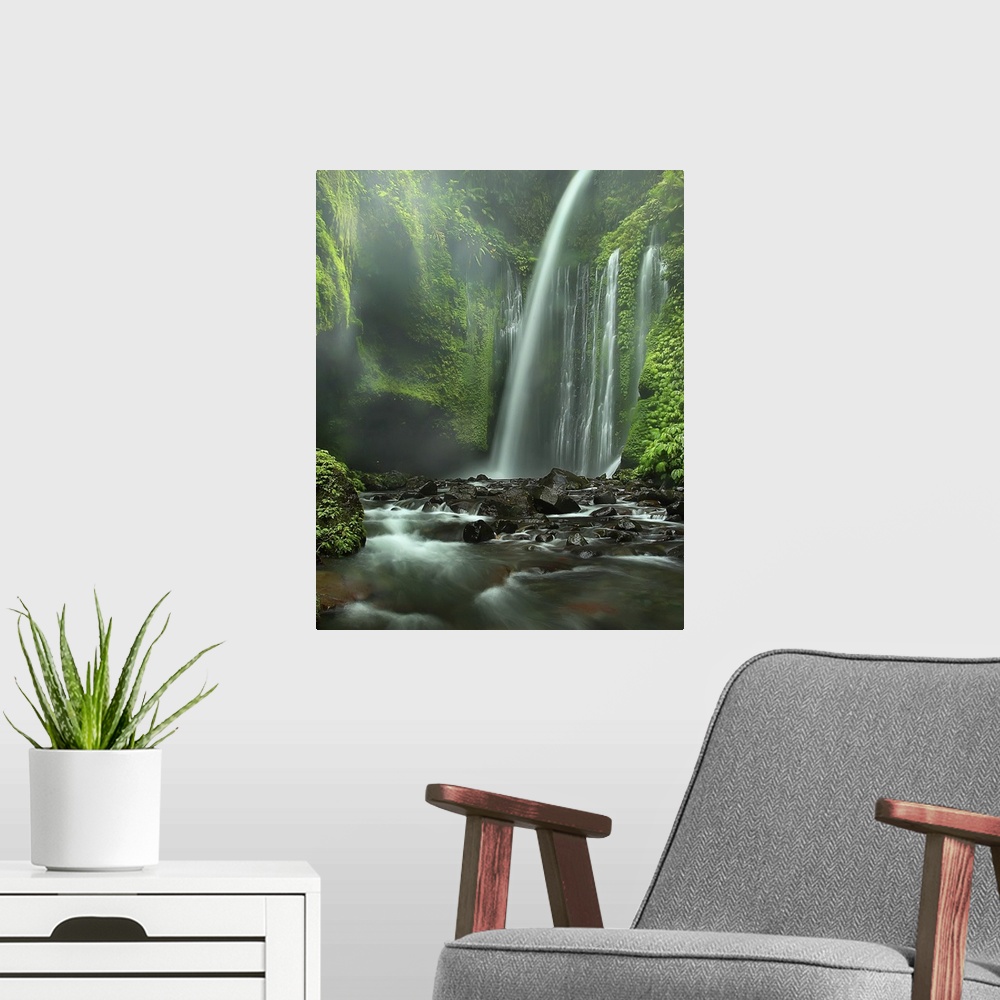 A modern room featuring A majestic waterfall in a cliff covered in lush vegetation, Indonesia.