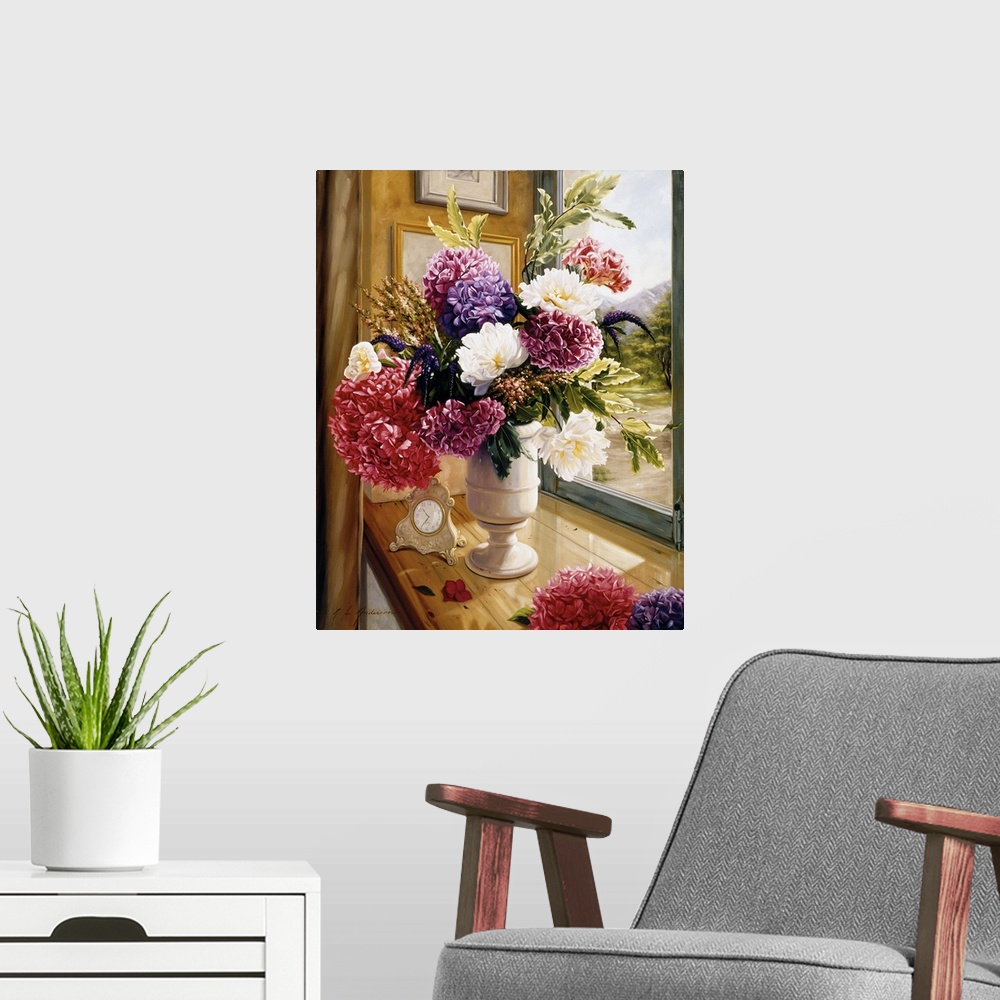 A modern room featuring Bouquet of flowers in a tall white vase on a table with a vintage clock on it with a window overl...