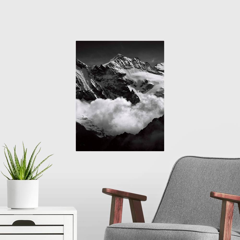 A modern room featuring Black and white photograph of mountain peaks surrounded by rolling clouds.