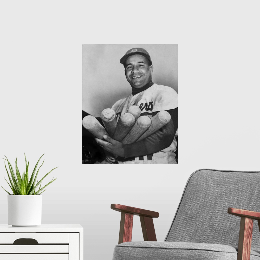 A modern room featuring Roy Campanella, catcher for the Brooklyn Dodgers, holding six bats, June 4, 1953. He was one of t...