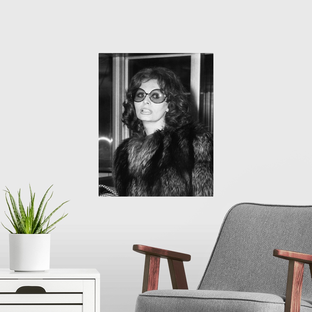 A modern room featuring Sophia Loren in large sunglasses and fur at Rome's airport, May 14, 1974.