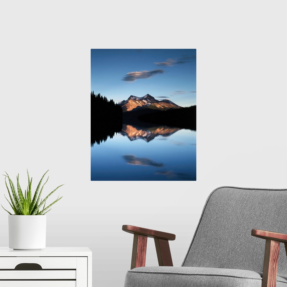 A modern room featuring Clouds and sunset light on the mountains reflected in the lake below in Jasper National Park, Alb...