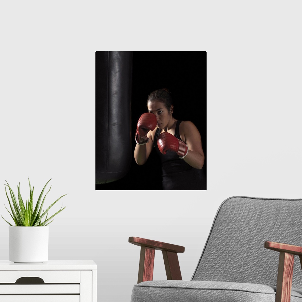A modern room featuring Female boxer training on punching bag