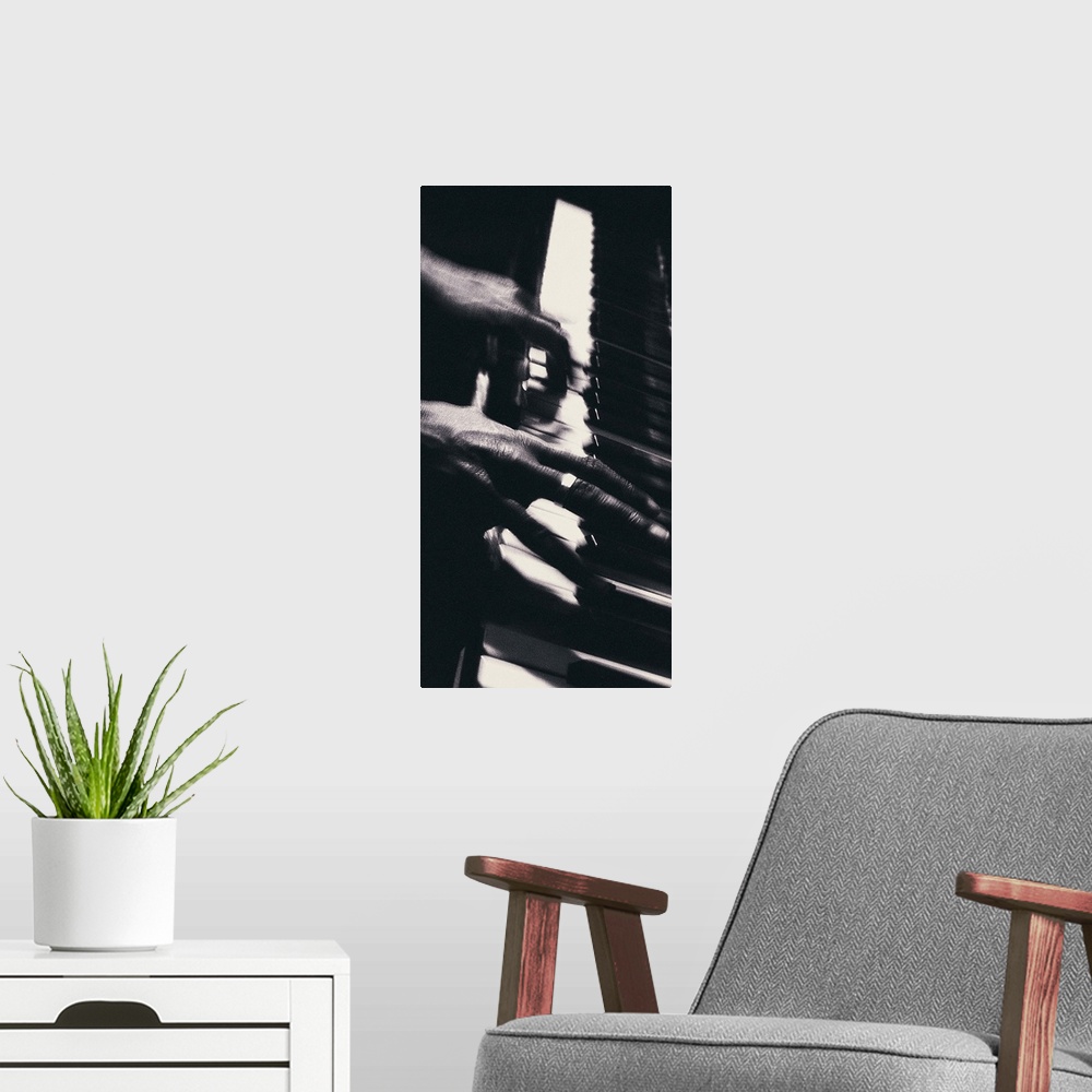 A modern room featuring Hands playing piano keys