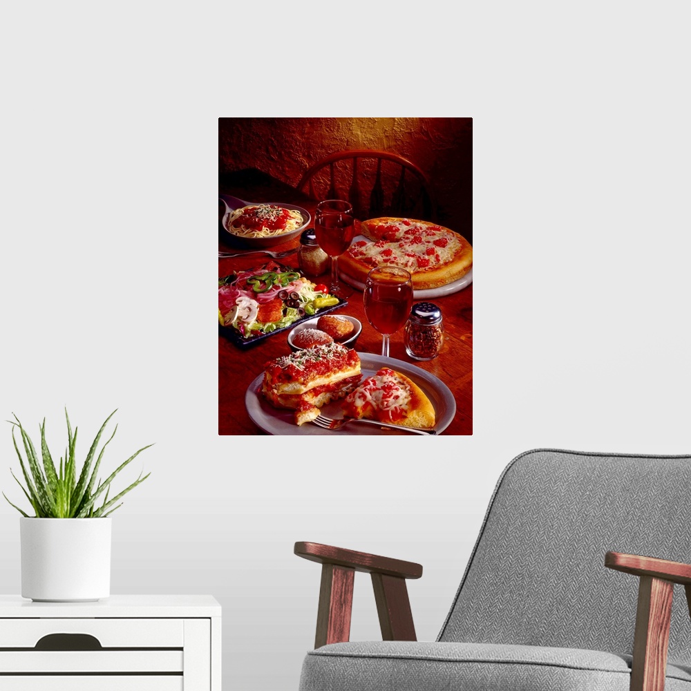 A modern room featuring Photograph taken of a table covered with plates of Italian food that includes pasta, pizza and an...