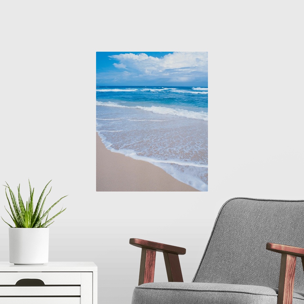 A modern room featuring Photograph of small waves lapping on the white sandy beach.