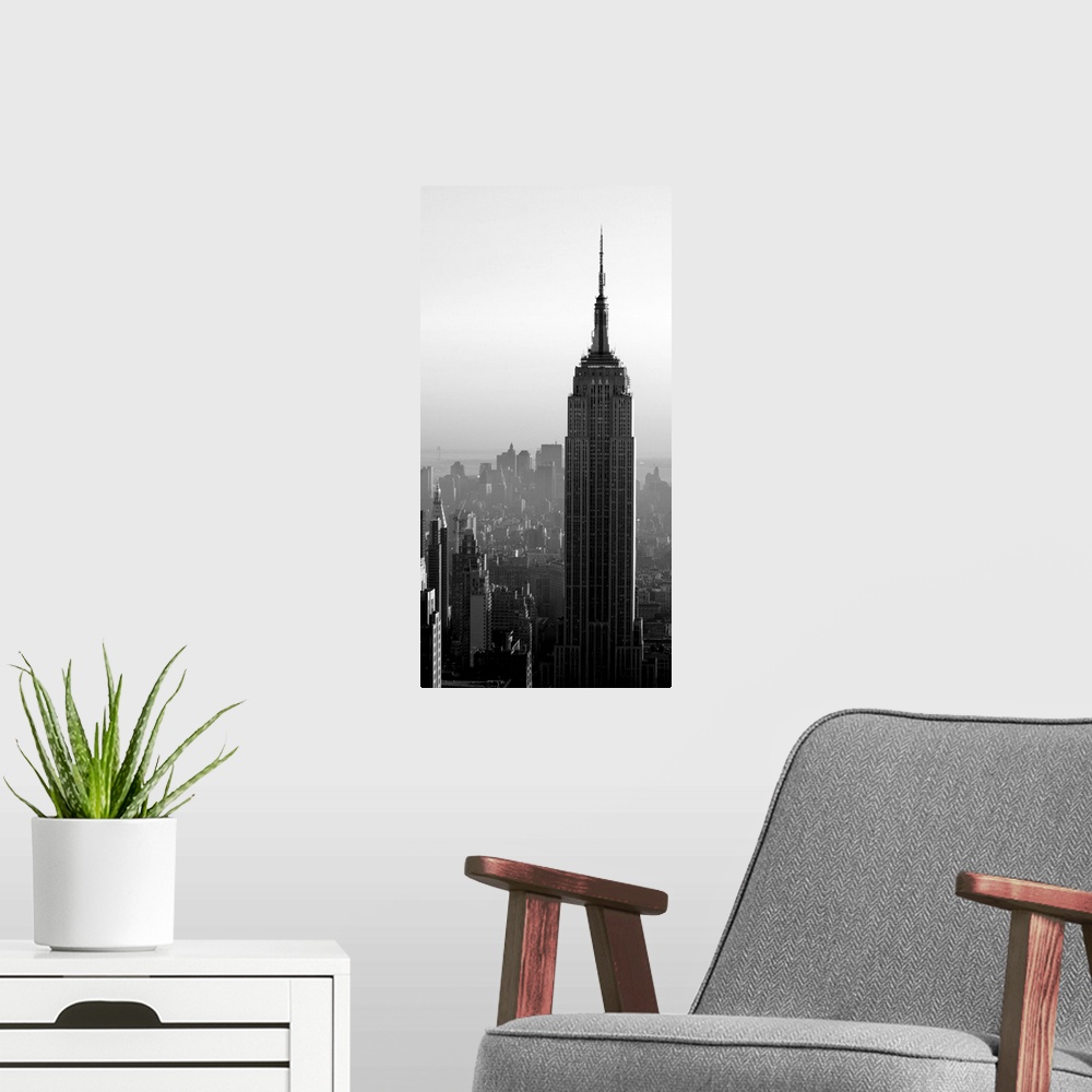 A modern room featuring A long vertical black and white image of the Empire States Building in New York City.