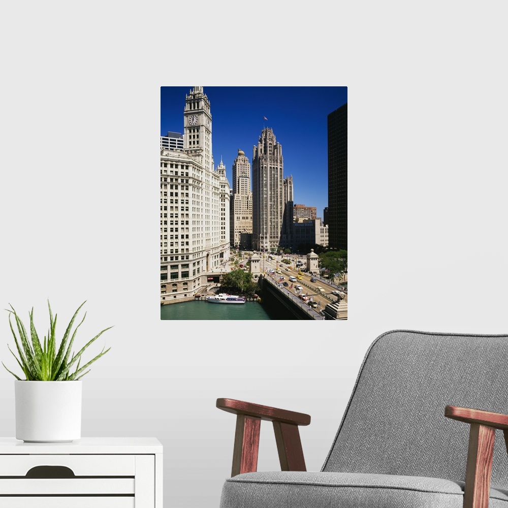 A modern room featuring Tall skyscraper buildings in downtown Chicago along the river as cars hustle about the busy streets.
