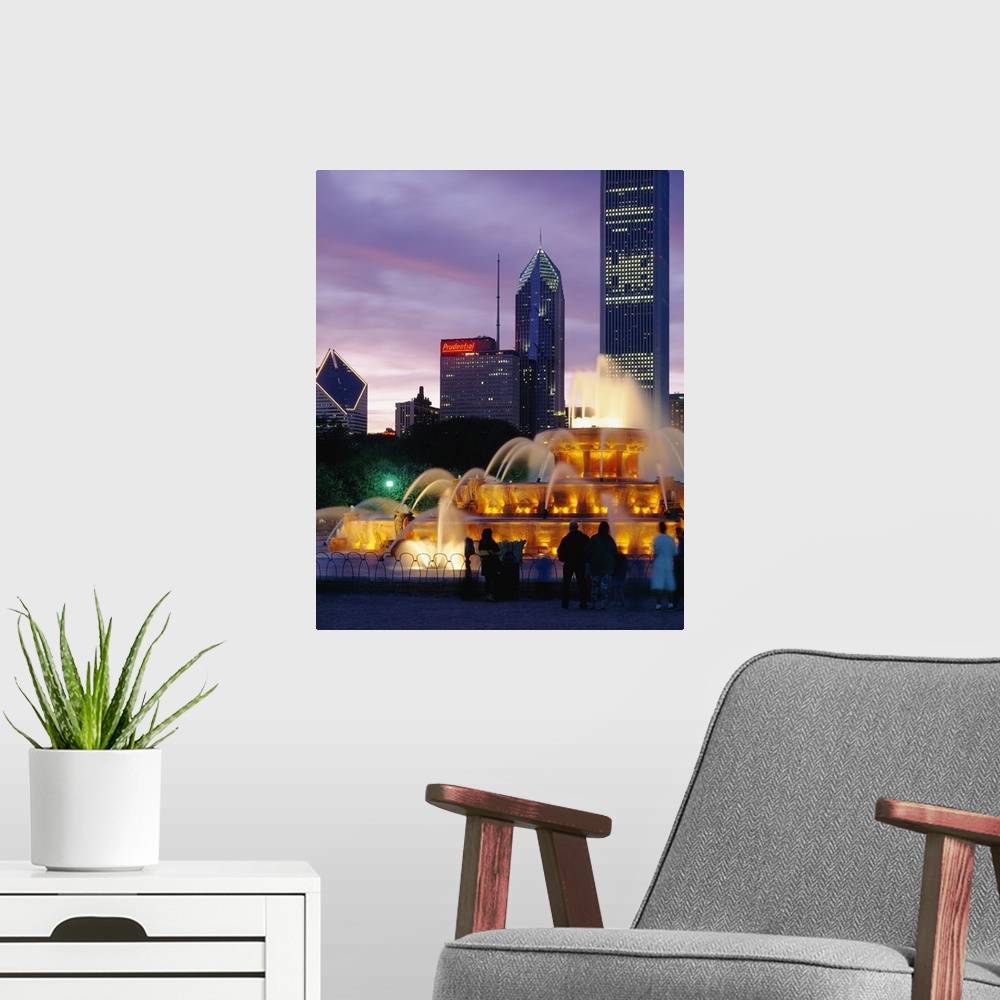 A modern room featuring Vertical photograph on a large wall hanging of Buckingham Fountain, lit at night, in Grant Park, ...