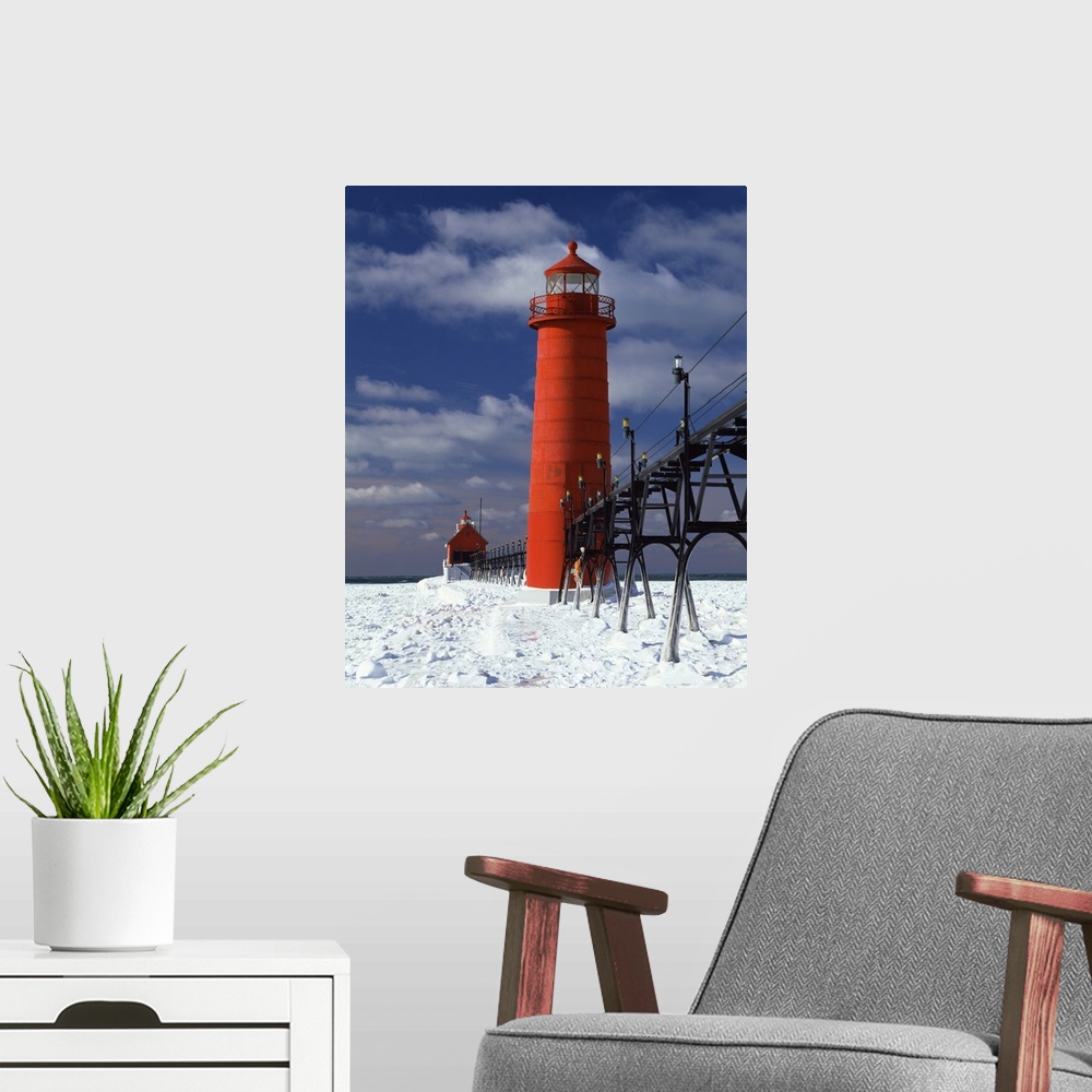 A modern room featuring A lighthouse in Michigan is photographed closely as snow covers the ground surrounding it.
