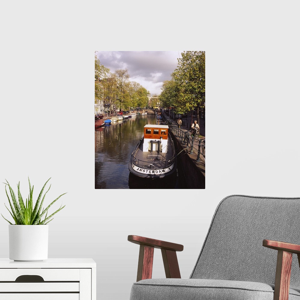 A modern room featuring Tourboat docked in a channel, Amsterdam, Netherlands