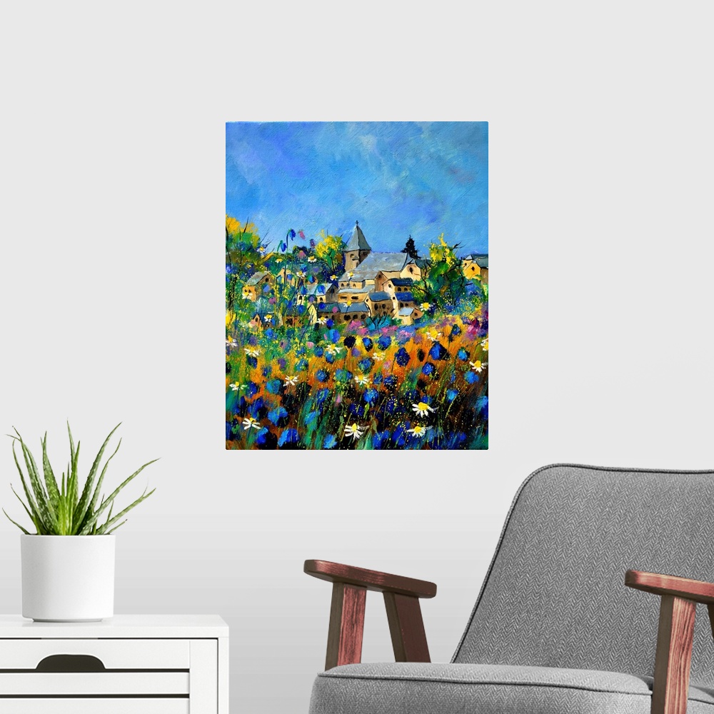 A modern room featuring Vertical painting of a field of colorful flowers in the foreground and a Belgium village in the b...