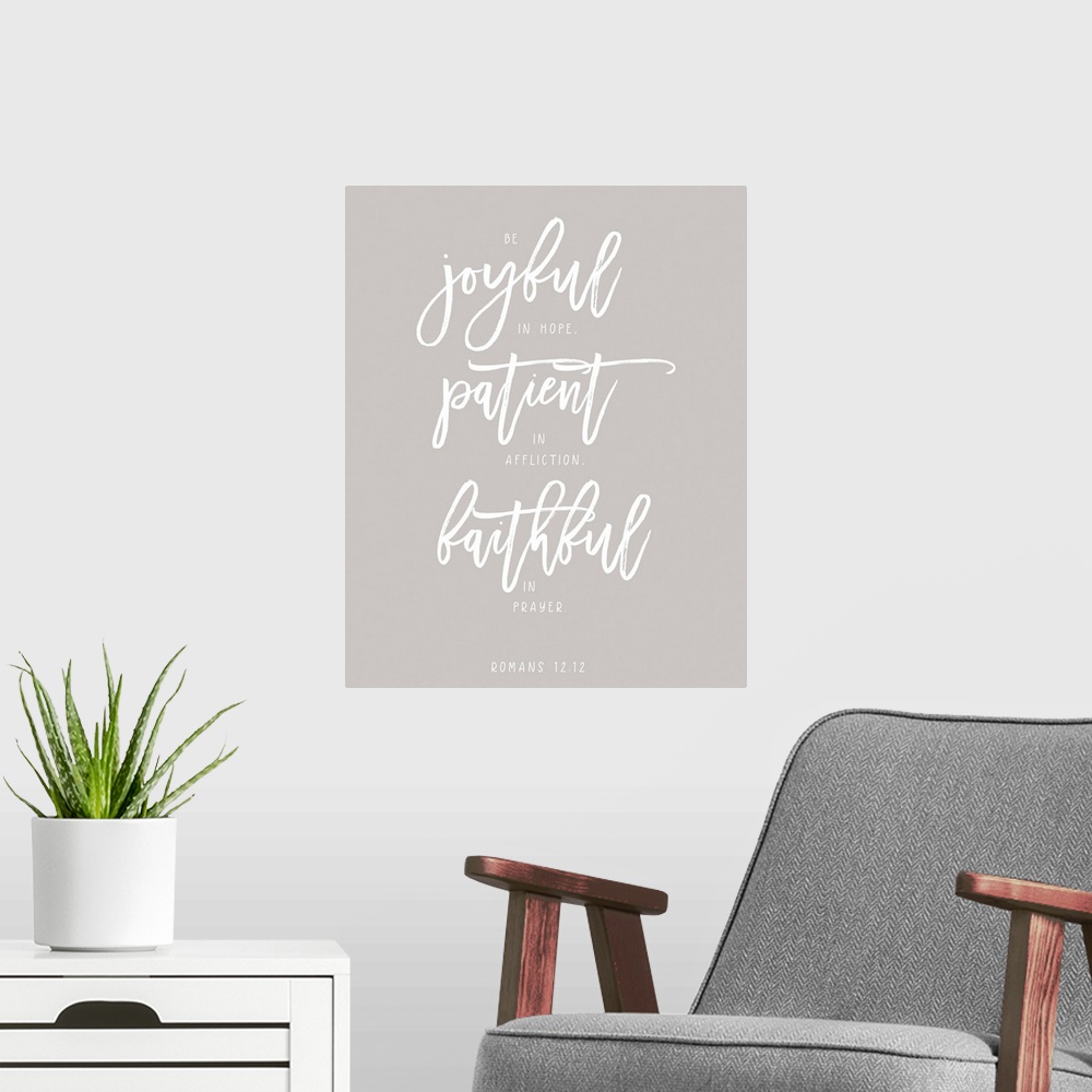A modern room featuring Handlettered Bible verse reading Be joyful in hope, patient in affliction, faithful in prayer.