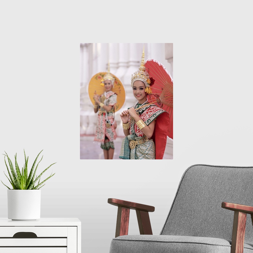 A modern room featuring Portrait of two dancers in traditional Thai classical dance costume, smiling and looking at the c...