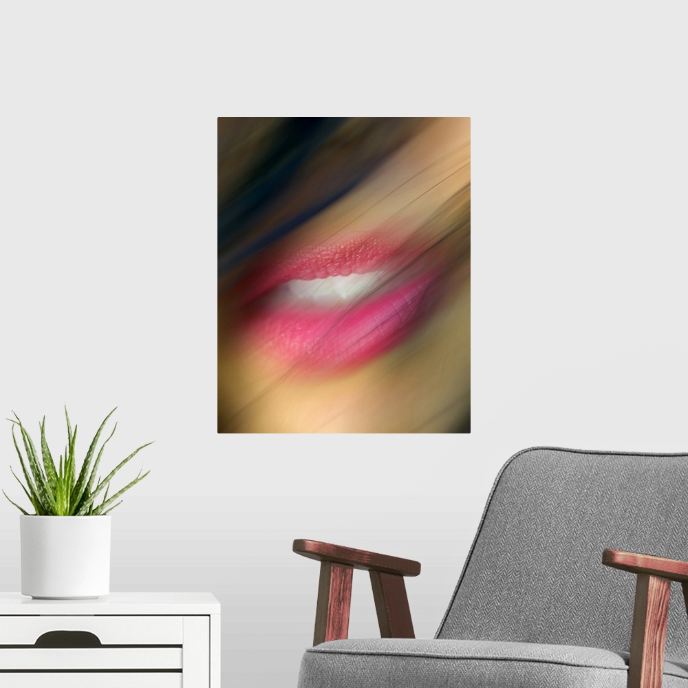 A modern room featuring Hair blows in front of a woman's lips that are photographed closely and appear slight blurry.