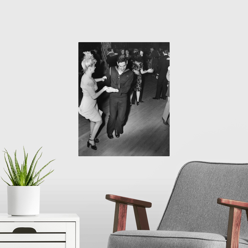 A modern room featuring A sailor and his girlfriend dance the Jitterbug at the Hurricane dancehall in New York City. Phot...