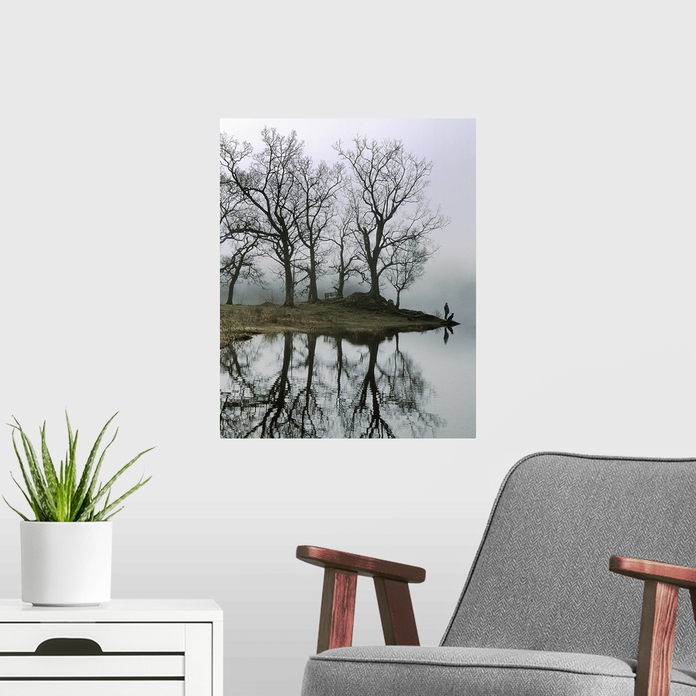 A modern room featuring A figure with a dog standing beside a lake with trees