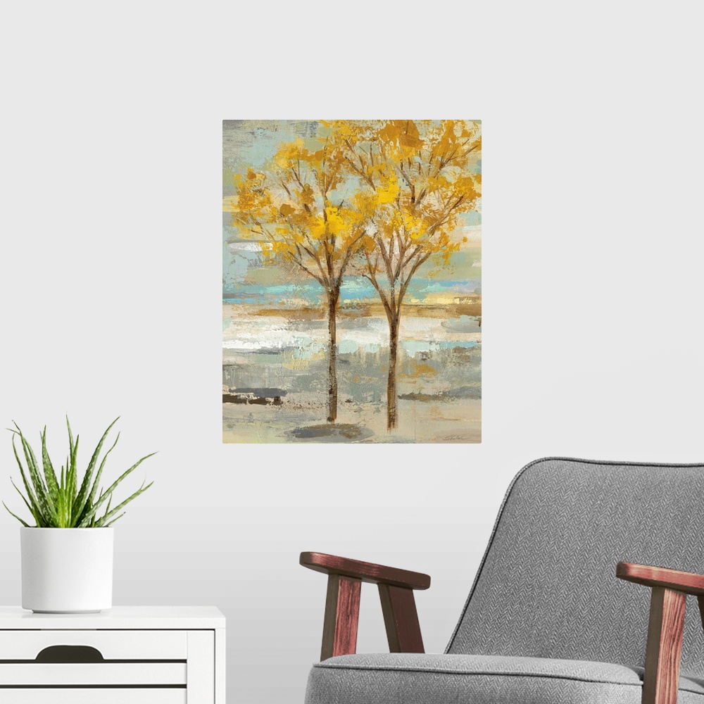 A modern room featuring Abstract painting of two golden leafed trees on a colorful background made up of blue, green, tan...