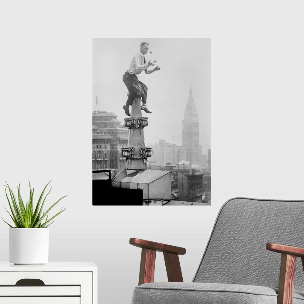 A modern room featuring Human Fly' John 'Jammie' Reynolds juggles while balancing atop a roof decoration in New York City...