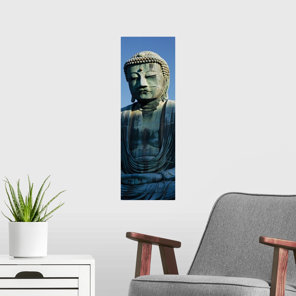 A modern room featuring Only part of a Buddha statue is photographed for this tall panoramic piece.