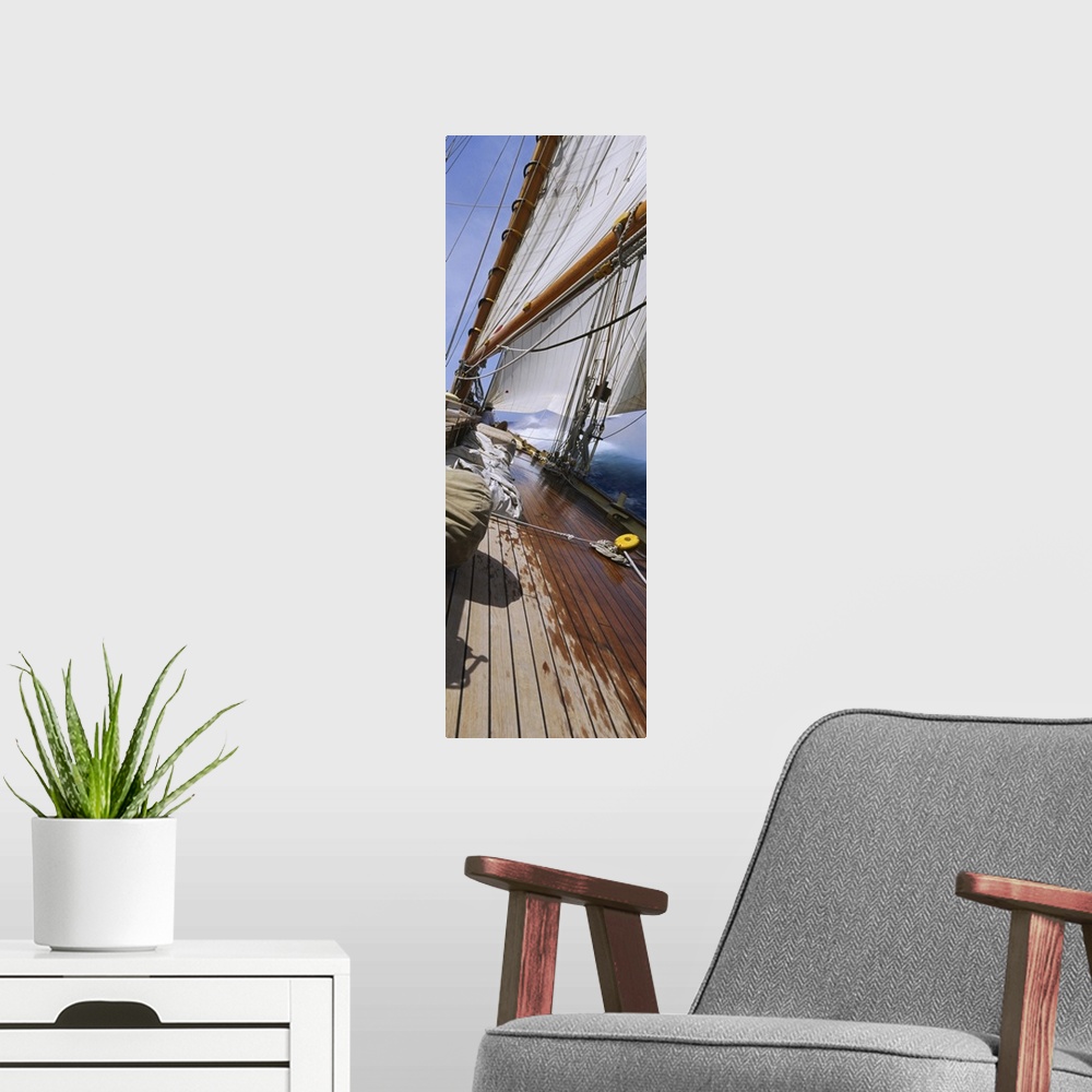 A modern room featuring Vertical panorama of the deck of a sail boat as it tips starboard in water with the sails at full...