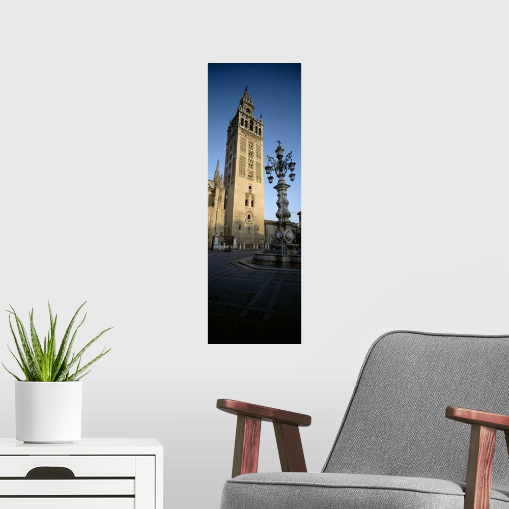 A modern room featuring Low angle view of a lamppost in front a church, La Giralda, Seville Cathedral, Seville, Seville P...
