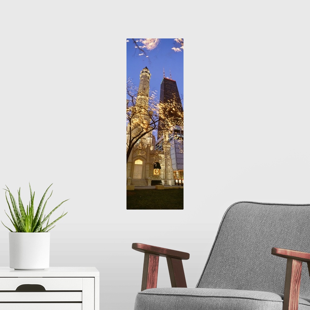 A modern room featuring Vertical, low angle photograph on a big canvas, of the Old Water Tower, lit up at night, seen thr...