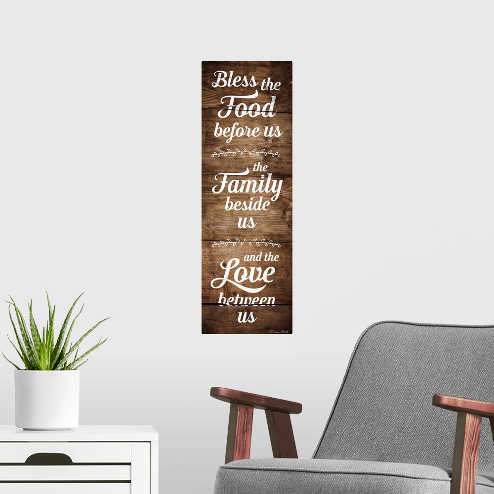 A modern room featuring Typography art in white script of a prayer honoring food, family, and love with a wooden board ba...