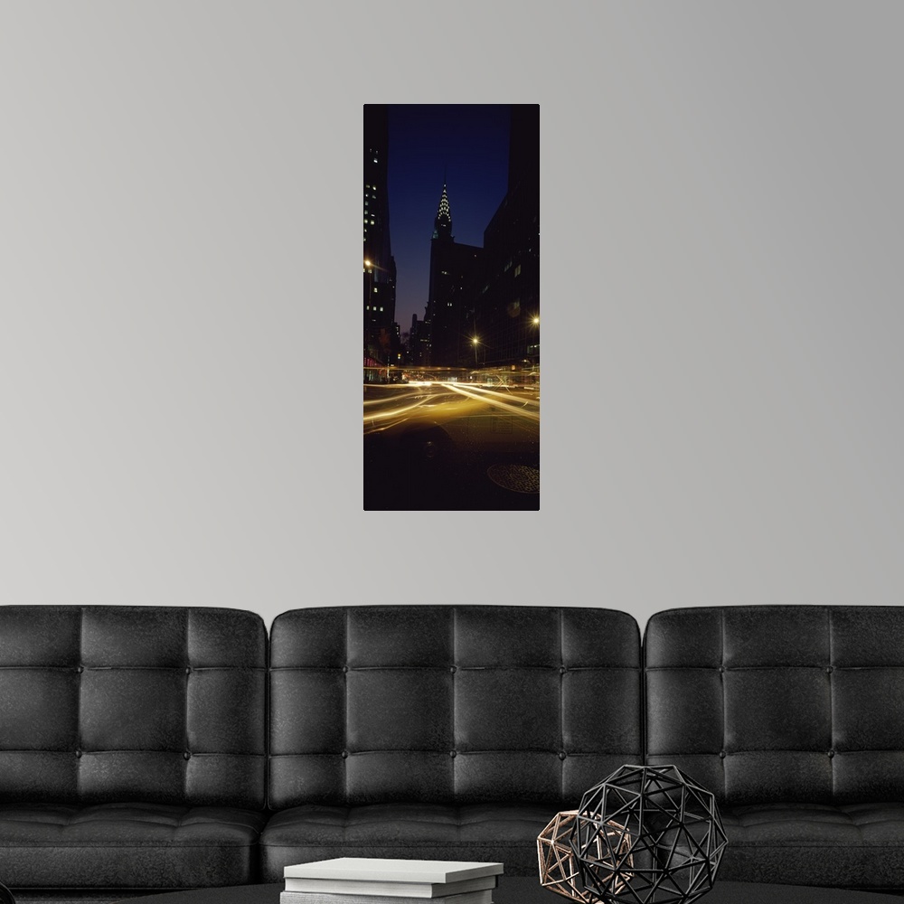 A modern room featuring Vertical panoramic photograph of street with light trails lined with lit up buildings in the ""Bi...