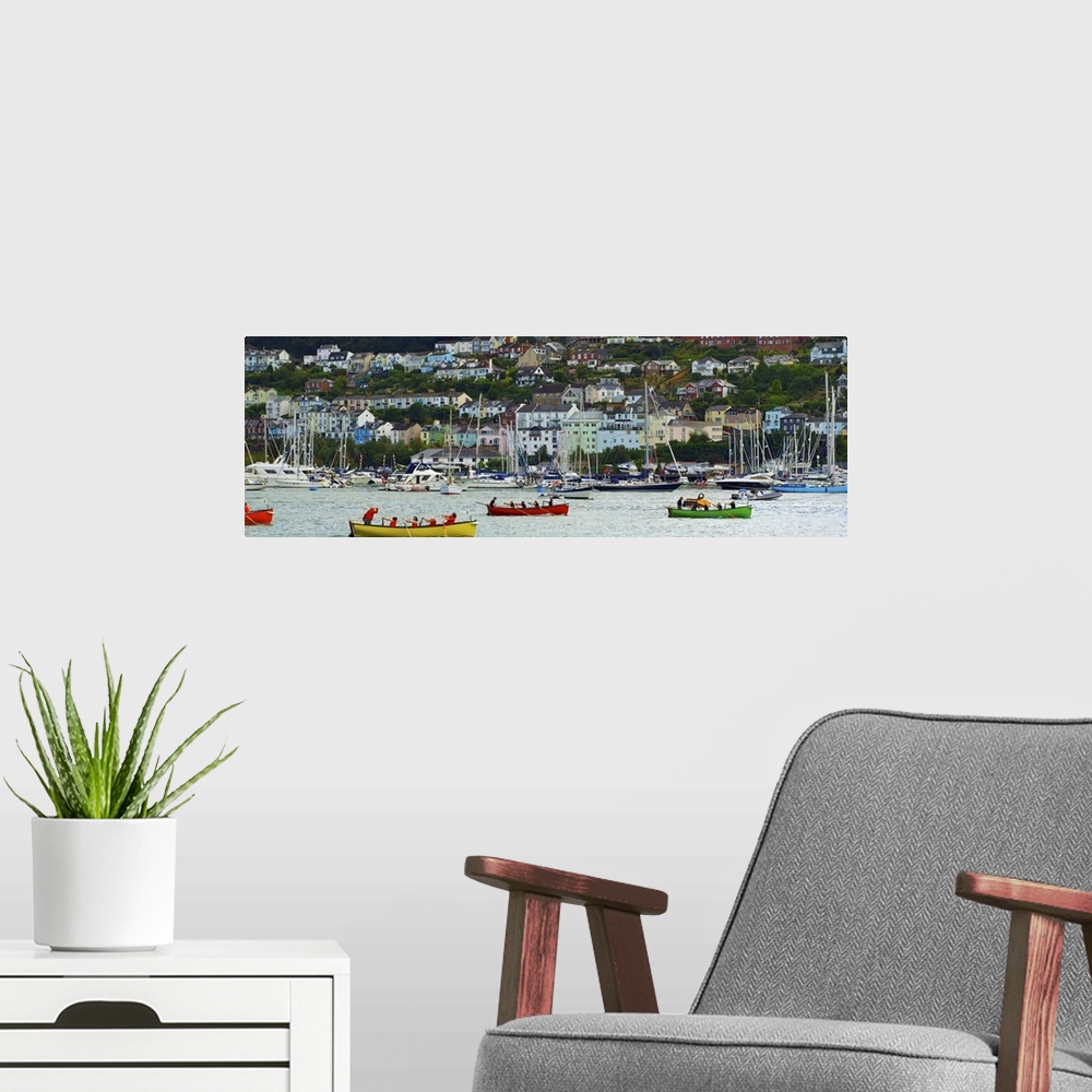 A modern room featuring Contemporary scenic painting of a harbor town with a regatta taking place.