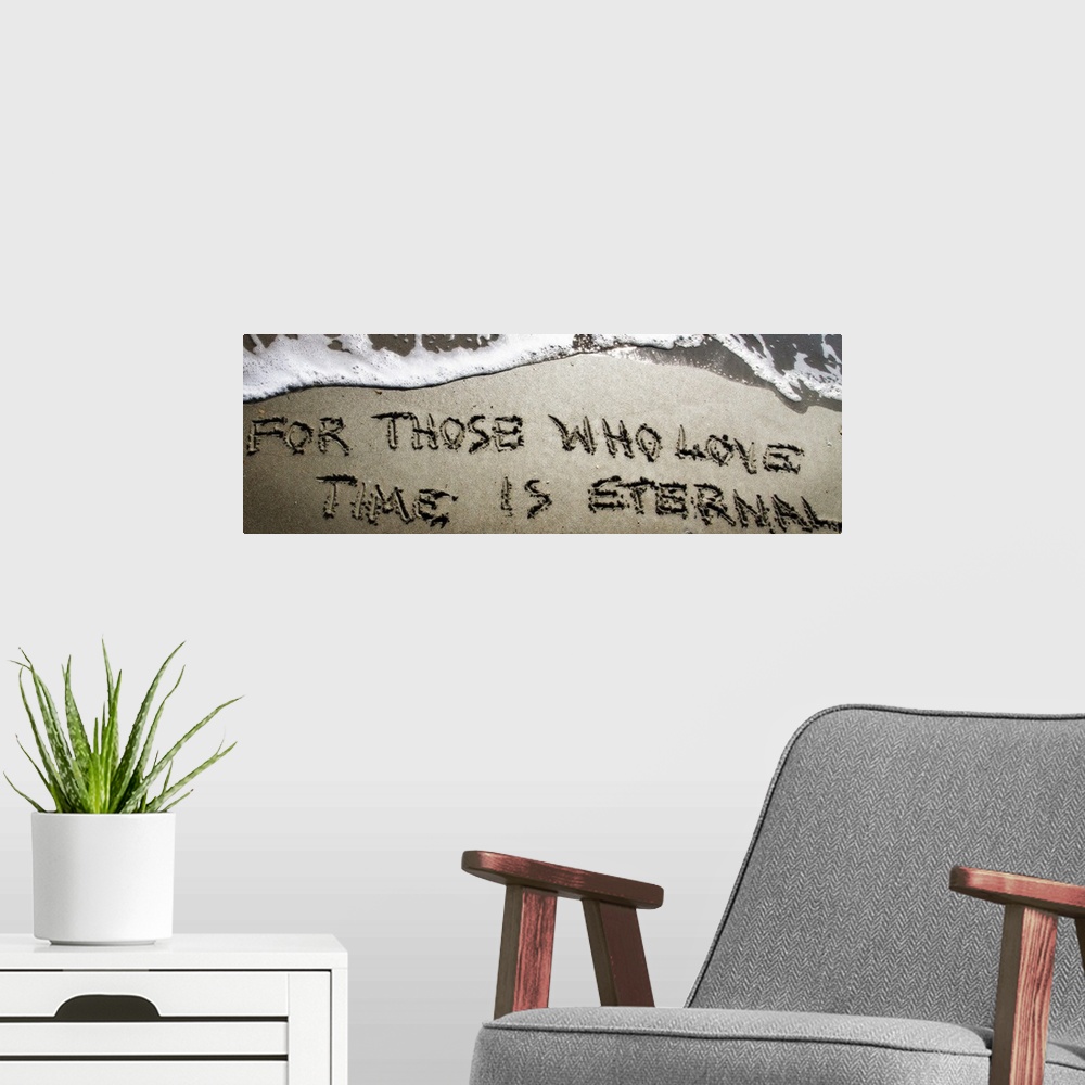 A modern room featuring A Bible verse drawn in the sand near the ocean water.