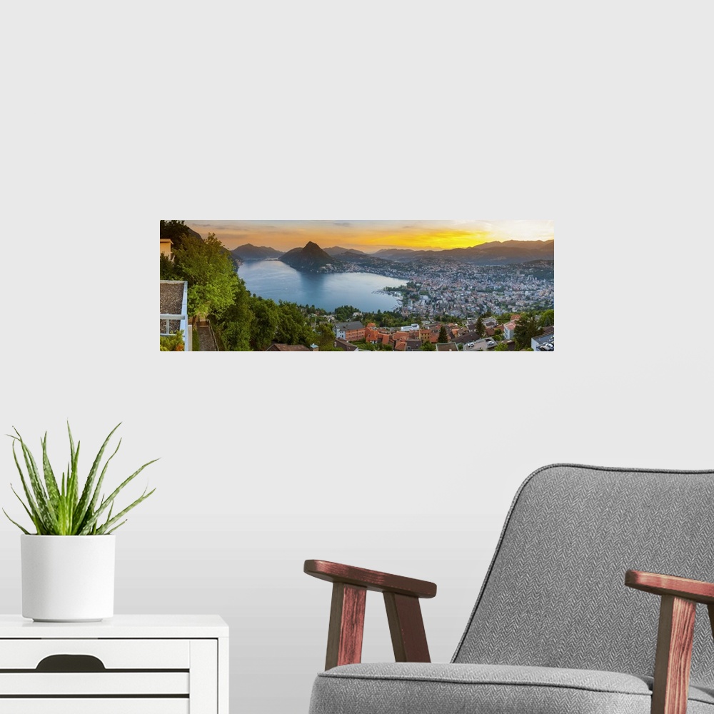 A modern room featuring Elevated view over Lugano illuminated at sunset, Lake Lugano, Ticino, Switzerland.