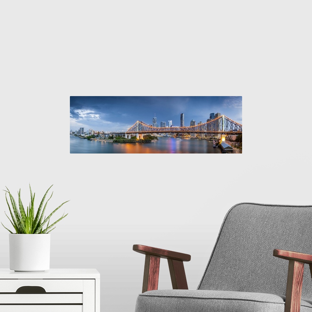 A modern room featuring Colourful reflections in the Brisbane River as storm clouds gather over the Story bridge and the ...