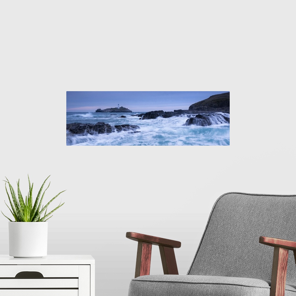 A modern room featuring Waves crash around the rocks near Godrevy Lighthouse, Cornwall, England. Winter (February)