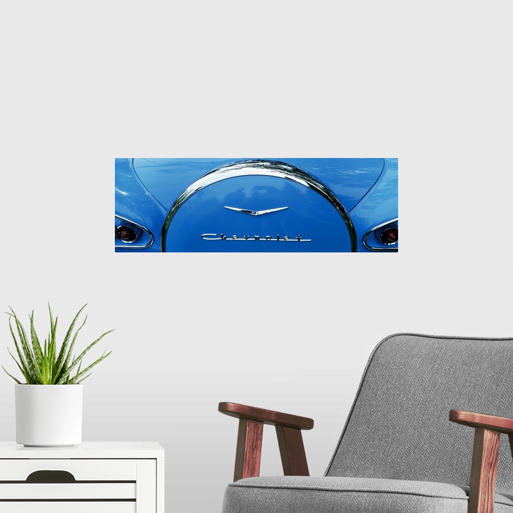 A modern room featuring Oversized, landscape photograph of the back end of a shiny blue 1958 Chevrolet Bel-Air, including...