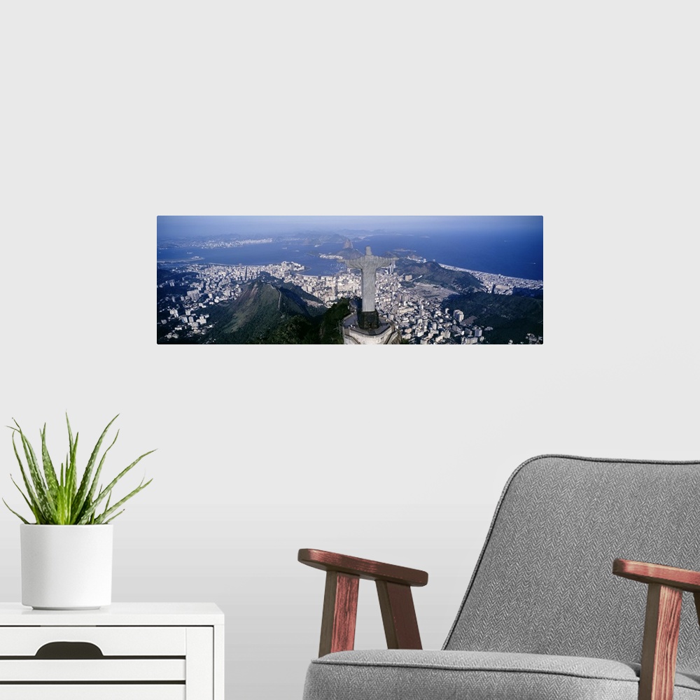 A modern room featuring Giant, landscape photograph of the back of Christ the Redeemer statue overlooking Rio de Janeiro,...