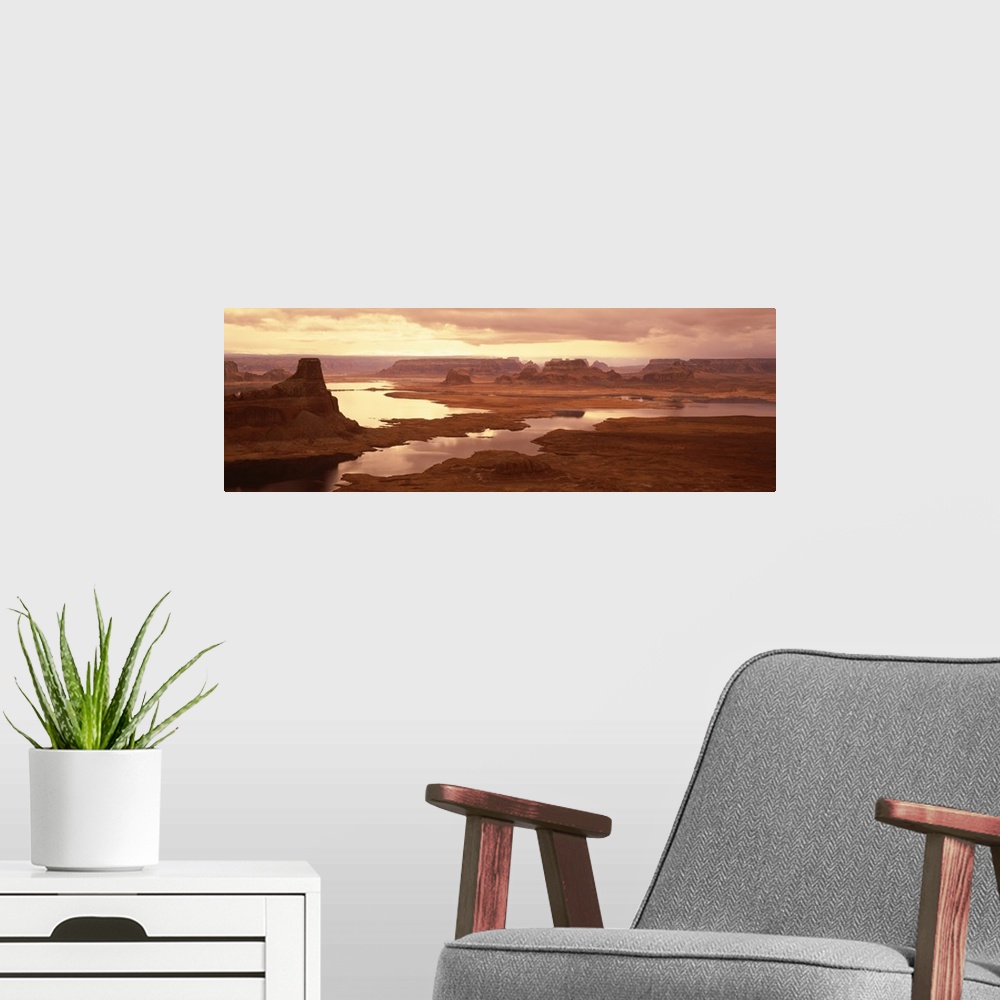 A modern room featuring Large panoramic photograph of the sun beginning to rise over Lake Powell and the red rock desert ...