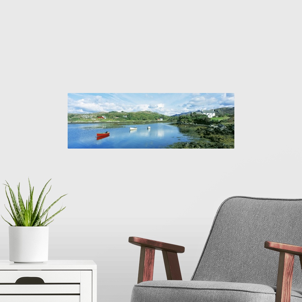 A modern room featuring Panoramic photograph of canoes in the water with land and houses in the distance under a cloudy sky.