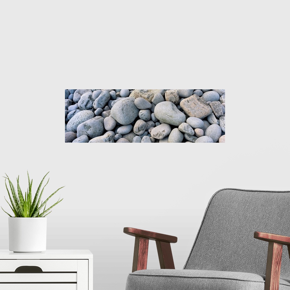 A modern room featuring Up-close panoramic photograph of seaside pebbles and rocks.
