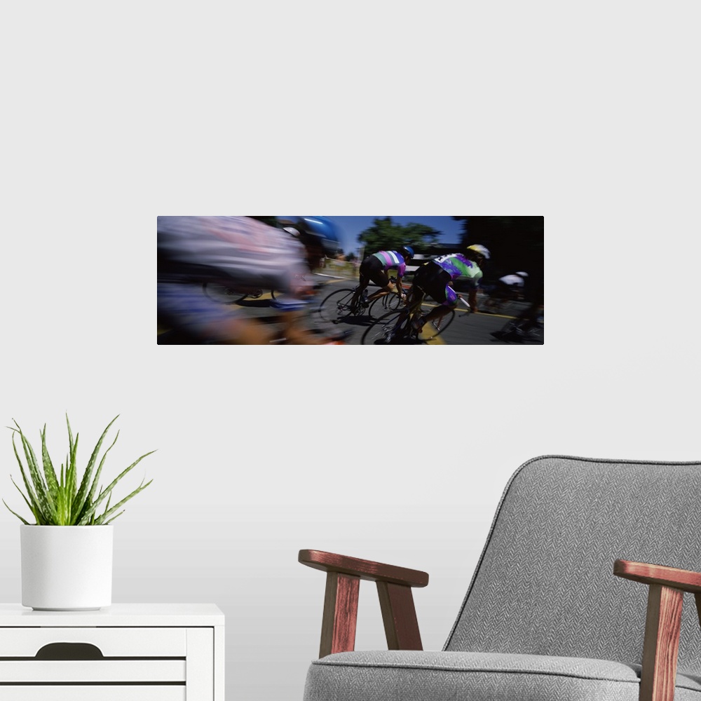 A modern room featuring Panoramic blur motion photograph of cyclists racing on the street.